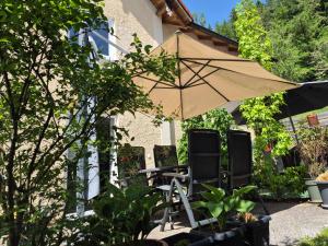 a table and two chairs and an umbrella at i24rooms in Legau