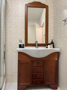 a bathroom with a sink and a mirror at Dare apartments 3 in Giurgiu +25 photos