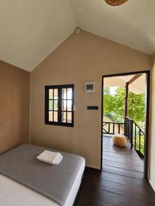 a bedroom with a bed and a sliding glass door at Flow Jungle Residency in Haad Yao