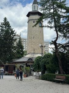 a tall tower with a clock on top of it at Dare apartments 3 in Giurgiu