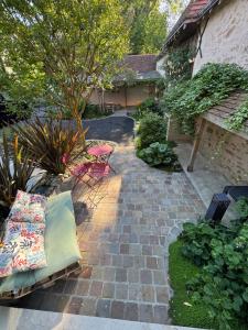 a patio with a couch and a table and chairs at Guest House de Céline et Benoît in Rivarennes