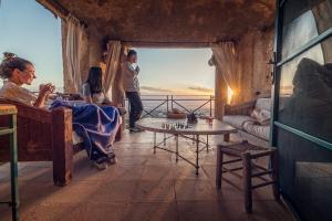 a group of people sitting in a room with a window at Beit Al Fannan in Ţabaqat Faḩl