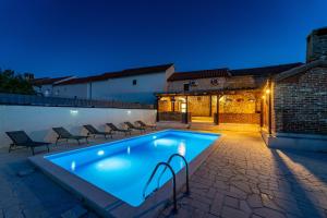 a swimming pool in a backyard at night at Villa Dora with heated pool & fitness in Gradina