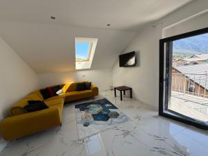 a living room with a yellow couch and a window at SC Apartments Bad Goisern - contactless check in in Bad Goisern