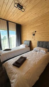 two beds in a room with wooden walls at Шервуд in Myta +171 photos