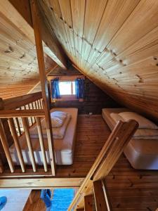 an attic room with two bunk beds and a window at Dalen Gaard camping og hytter in Geiranger