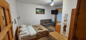 a small room with a bed and a chair at Pensiunea TOP DEMAC in Slănic
