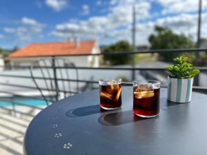 two drinks sitting on a table on a balcony at Casa das Flores in Batalha
