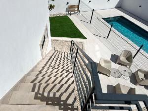 a staircase leading up to a swimming pool with chairs and a swimming pool at Casa das Flores in Batalha