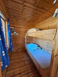 a room with two bunk beds in a wooden cabin at Dalen Gaard camping og hytter in Geiranger