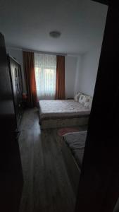 a small bedroom with two beds and a window at Casă in Năvodari
