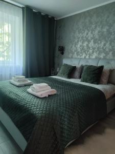 a bedroom with a bed with two towels on it at JOJO Loft Comfort Dzelzavas & Cozy Stay & Breakfast Gift in Riga
