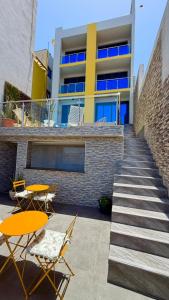 a building with tables and chairs in front of a building at Vista Mar Suites in Praia +8 photos
