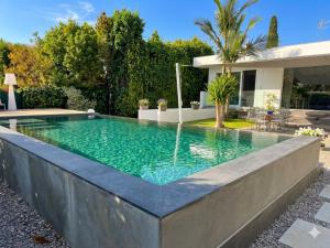 a swimming pool with a fountain in front of a house at Mondello Luxury villa in Palermo