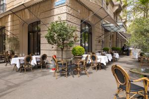 an outdoor patio with tables and chairs and a building at Hotel Europe in Zurich