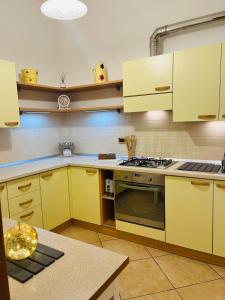 a kitchen with yellow cabinets and a stove at Blue House in Martinsicuro
