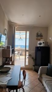 a living room with a table and a couch with a view at Terrazza Enjoy in Letojanni