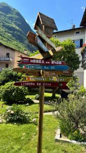 a wooden sign with many signs on a pole at La Casa di Adele in Tirano