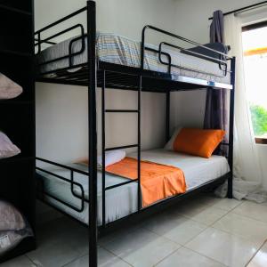 a bedroom with two bunk beds with an orange pillow at OasisBhmz in Ponta do Ouro