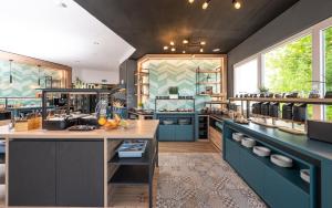 a large kitchen with blue cabinets and a counter at Berghotel Kristall in Idar-Oberstein