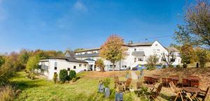 a house on a hill with tables and chairs at Berghotel Kristall in Idar-Oberstein