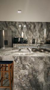 a counter in a kitchen with a stone wall at OasisBhmz in Ponta do Ouro