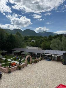 a building with a patio with mountains in the background at Riverside Rooms Klos in Klos