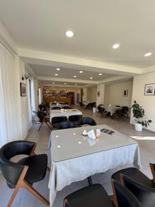 a large room with tables and chairs and tablesearcher at La Montagna in Bangveti
