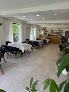 a dining room with tables and chairs and windows at La Montagna in Bangveti
