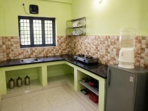a kitchen with a counter with a sink and a refrigerator at Southern Residency in Ferokh