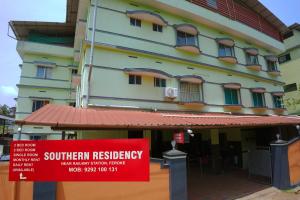 a building with a red sign in front of it at Southern Residency in Ferokh