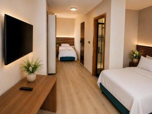 a hotel room with two beds and a flat screen tv at Blue Park Beach Otel in Ayvacık