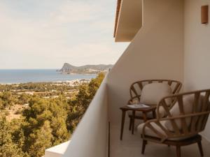 a balcony with a chair and a table and the ocean at Besai Ibiza Boutique Hotel - New Opening in San Jose