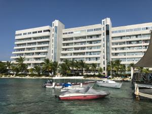 a large building with boats in the water in front of it at Apartamento Sunrise con vista interna o con vista al mar in San Andrés