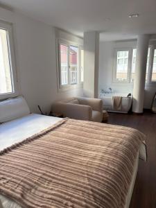a bedroom with a bed and a couch and windows at Ribeira Penélope in Ribeira