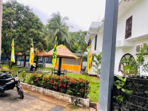 a motorcycle parked in front of a building with flags at The Dream City Hotel in Kilinochchi