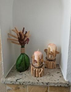 two candles on a table with a green vase at Serviced Rooms ''Krone'' in Creglingen