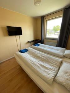 a bedroom with a large bed with a tv on the wall at Nya Dacke in Virserum