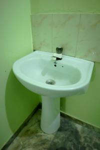 a white sink in the corner of a bathroom at Southern Residency in Ferokh