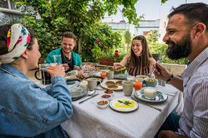 a group of people sitting around a table eating food at Beit Al Baraka in Um Qeis