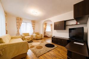 a living room with a couch and a flat screen tv at Casa Valeria Voronet in Voronet