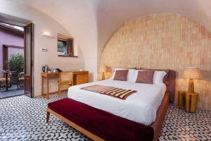 a bedroom with a large bed and a table and a desk at Relais San Giuliano in Viagrande +115 photos