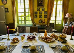 a table with food on it in a dining room at Demeure Le Ragois de Bretonvilliers - un voyage au cœur du temps - Richelieu in Richelieu