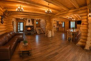a living room with a couch and a fireplace in a log cabin at Casa Pădurarului in Câmpulung Moldovenesc