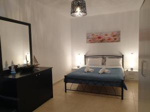 a bedroom with a bed and a dresser and a mirror at Kanari Holiday Home in Gourna