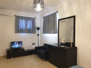 a living room with a mirror and a tv at Kanari Holiday Home in Gourna