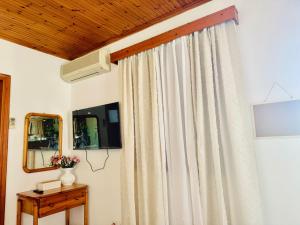 a room with a curtain and a mirror at Gradakia Cottages 1 in Argostoli