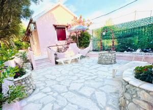 a patio with two chairs and an umbrella at Gradakia Cottages 1 in Argostoli