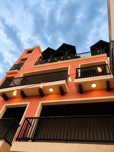 ein hohes orangefarbenes Gebäude mit vielen Fenstern in der Unterkunft Hotel Barrio Boutique in Monterrey + 6 Fotos