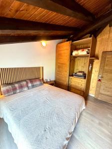 a bedroom with a large bed and a wooden ceiling at Belle vue des Alpes in Blavy